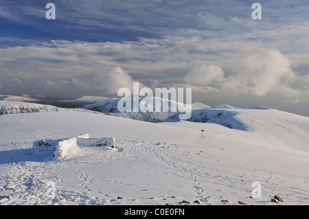 Drammatica cieli nuvolosi su Helvellyn in inverno nel Lake District inglese, Nethermost Pike e Dollywagon Pike in background Foto Stock