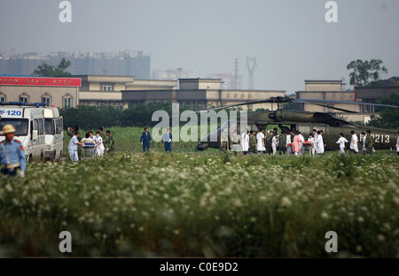 Lavoratori medici e popolare di liberazione soldati dell esercito trasportare i feriti fuori di elicotteri in Fenghuangshan aeroporto di Chengdu Foto Stock