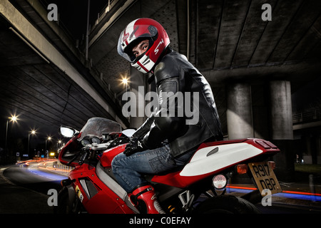 Ritratto di un giovane uomo su una motocicletta rossa Foto Stock