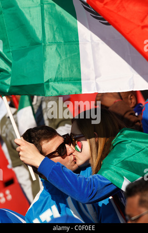 In Italia i sostenitori di baciare e tenendo una bandiera italiana a 2010 FIFA World Cup match tra Italia e Slovacchia il 24 giugno 2010. Foto Stock