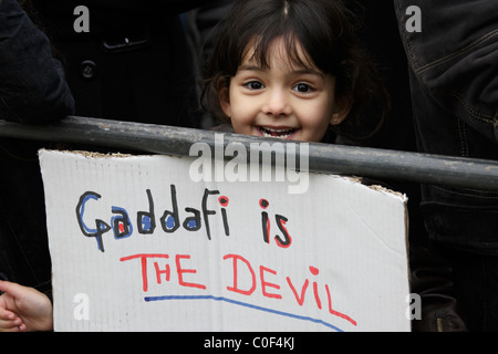 Un giovane bambino tiene anti Gheddafi cartelloni durante la demo in Londra Foto Stock