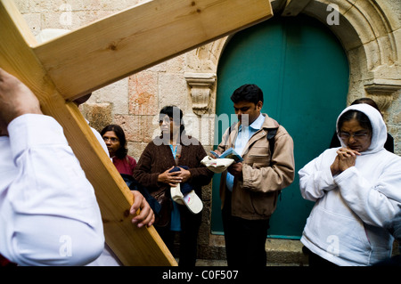 I cristiani indiani che tiene la croce su un religioso pellegrinaggio viaggio attraverso la Via Dolorosa nella città vecchia di Gerusalemme. Foto Stock