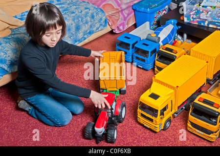 Bambino gioca con il giocattolo camion e trattori Foto Stock