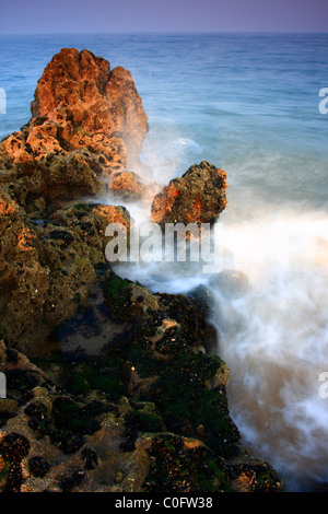 Onda in arrivo la rottura su un affioramento di roccia, Tenby, Pembrokeshire, Galles Foto Stock