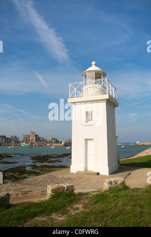 Faro e il porto di Barfleur (Manche department, Bassa Normandia, Francia), con la chiesa di Saint-Nicolas. Foto Stock