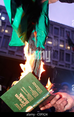 Londra, Regno Unito. Durante una manifestazione di protesta al di fuori dell'ambasciata statunitense di manifestanti libici masterizzare Gheddafi libro verde e bandiera. Foto Stock