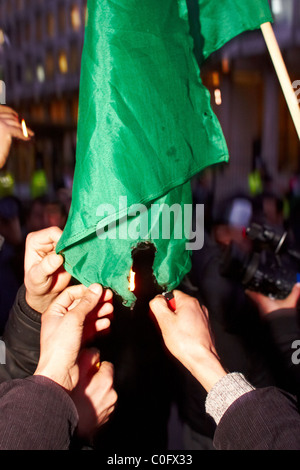 Londra, Regno Unito. Durante una manifestazione di protesta al di fuori dell'ambasciata statunitense di manifestanti libici masterizzare Gheddafi libro verde e bandiera. Foto Stock