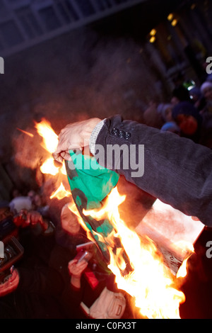 Londra, Regno Unito. Durante una manifestazione di protesta al di fuori dell'ambasciata statunitense di manifestanti libici masterizzare Gheddafi libro verde e bandiera. Foto Stock