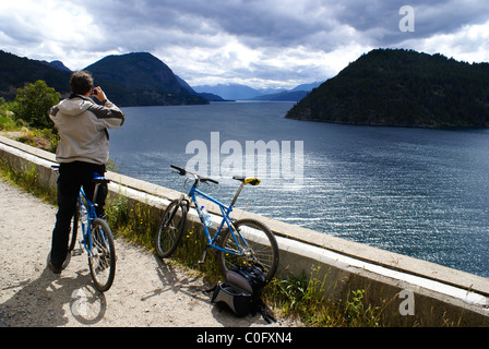 Turista su una bicicletta assume una foto del Lago Lacar vicino a San Martin de Los Andes, Neuquen, Argentina. Foto Stock