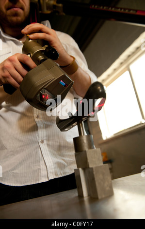 Un uomo che utilizza un laser scanner 3D ricevitore, REGNO UNITO Foto Stock