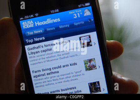 Una illustrazione della foto di una persona in possesso di un Iphone 3gs, mostrando l'USA Today News content provider app Foto Stock