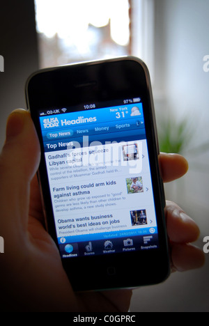 Una illustrazione della foto di una persona in possesso di un Iphone 3gs, mostrando l'USA Today News content provider app Foto Stock