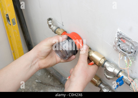 Installazione del misuratore di acqua in cucina. metallo-plastica tubo in PVC Foto Stock