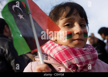 Ragazza giovane tiene la bandiera del Regno indipendente come esuli libici protesta al di fuori della loro Ambasciata a Londra. Foto Stock