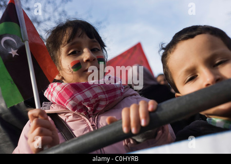 Ragazza giovane tiene la bandiera del Regno indipendente come esuli libici protesta al di fuori della loro Ambasciata a Londra. Foto Stock