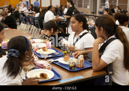 La scuola media di ragazze socializzare durante il pranzo nella caffetteria presso l'Ann Richards scuola per giovani donne leader in Austin in Texas Foto Stock