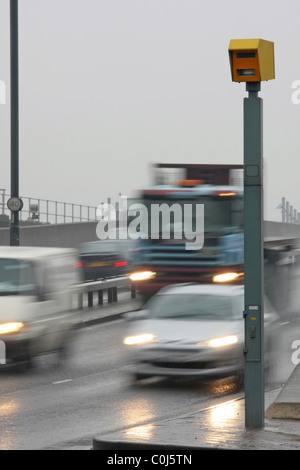 Veicoli che passano a un autovelox in condizioni di bagnato in Isle of Dogs, Londra, Inghilterra Foto Stock