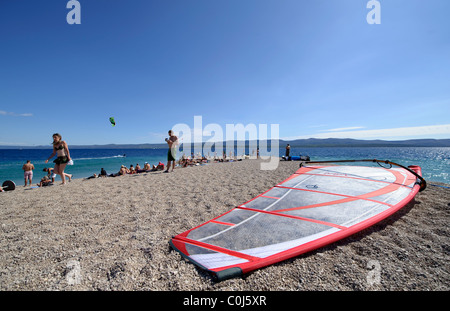 Un windsurf sulla ghiaia penisola di sabbia di Zlatni Rat, vicino a Bol, isola di Brac, Dalamatia costa, Croazia Foto Stock