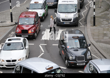 Attraversamento pedonale la guida reato pericolo a piedi la congestione del traffico strade di Londra auto taxi autobus attraversamento stradale pedoni Foto Stock