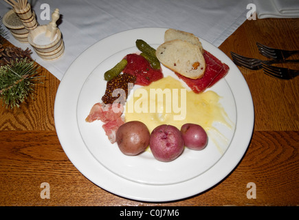 Piatto di formaggio raclette e di verdure a pranzo con caminetto a cena, Deer Valley, Utah. Foto Stock