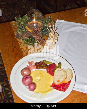 Piatto di formaggio raclette e di verdure a pranzo con caminetto a cena, Deer Valley, Utah. Foto Stock