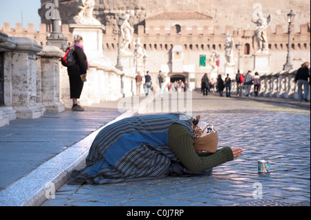 Zingaro femmina mendicante disteso sul marciapiede di Ponte Sant'Angelo, Roma. Foto Stock