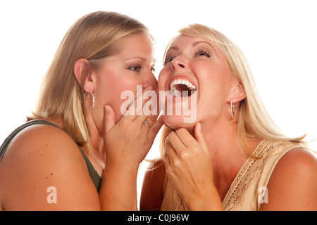 Due donna bionda ridere Whispering Secrets isolato su uno sfondo bianco. Foto Stock