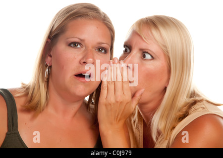 Due ragazze bionda Whispering Secrets isolato su uno sfondo bianco. Foto Stock
