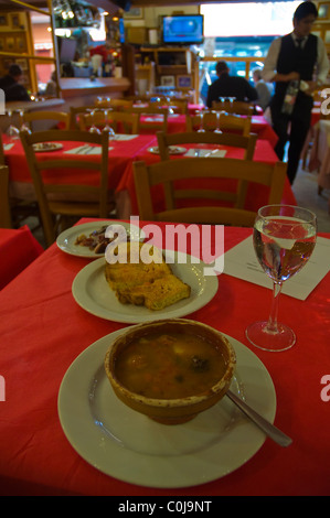 Saugage di lenticchie e zuppa di patate con pane e acqua nel ristorante nel quartiere della Barceloneta barcellona catalogna Spagna Europa Foto Stock