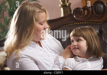 Giovane madre spazzole la figlia della capelli Foto Stock