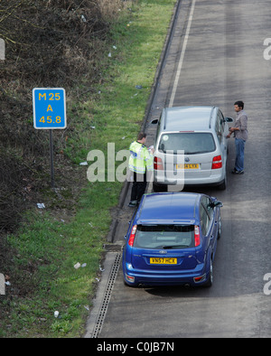 Persona che riceve un biglietto sulla M25. Foto Stock
