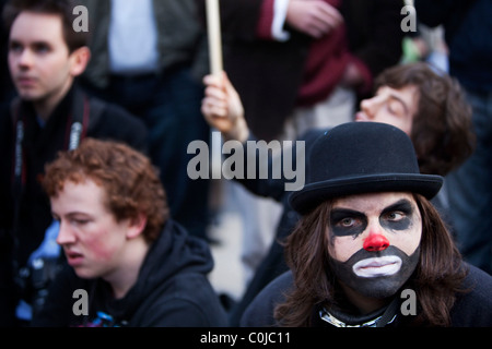 Manifestazione studentesca chiude Oxford Street portando i mezzi di trasporto pubblico per una sosta a Londra. Uomo vestito come un banchiere / clown. Foto Stock