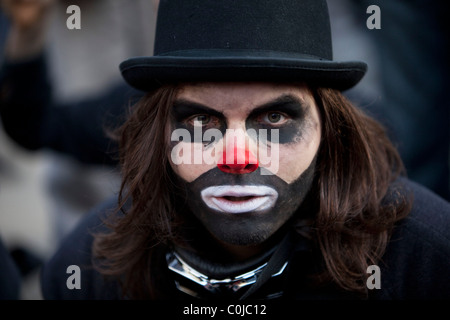 Manifestazione studentesca chiude Oxford Street portando i mezzi di trasporto pubblico per una sosta a Londra. Uomo vestito come un banchiere / clown. Foto Stock