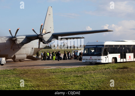 LUQA, MALTA - FEB 24 - I passeggeri che sono stati evacuati dalla Libia unboard un RAF C-130J Hercules Foto Stock