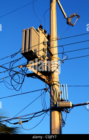 Il palo della luce di trasformatori di distribuzione cavi disordinati Foto Stock