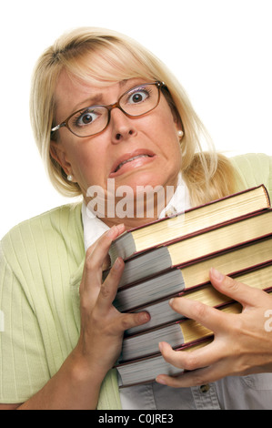 Sconcertata ragazza lotte con pila di libri isolato su uno sfondo bianco. Foto Stock