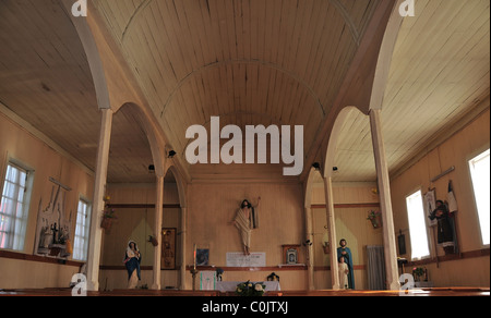 Luce naturale vista della chiesa in legno interno, con la Domenica di Pasqua Revivalista Cristo sopra l altare, Chacao, Isola di Chiloe, Cile Foto Stock