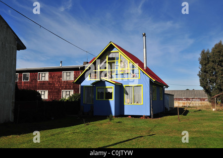 Vista Green di architettura Chilean-German case di legno, con scandole di marrone e blu tavole dipinte, Chacao, Isola di Chiloe, Cile Foto Stock