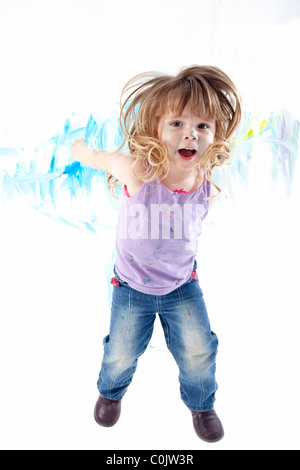 Jumping neonato con il dipinto di bianco parete in background Foto Stock