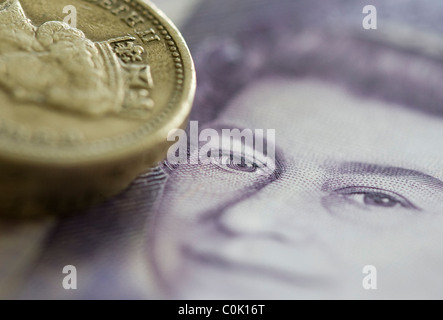 Venti sterline note e una libbra di monete sono impostati per una fotografia Foto Stock