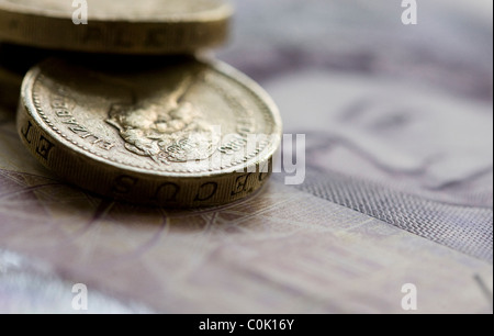 Venti sterline note e una libbra di monete sono impostati per una fotografia Foto Stock