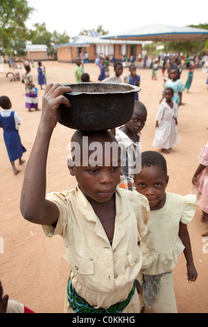 Un bambino porta acqua torna da un pozzetto ad una UNICEF-finanziato orfanotrofio di Dedza, Malawi, Sud Africa. Foto Stock