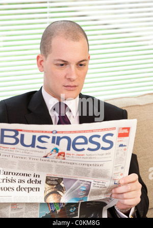 Uomo di lettura supplemento business nel giornale nel Regno Unito Foto Stock
