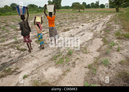 Le ragazze portano a casa di acqua da un pozzo in Safo, Mali, Africa occidentale. Foto Stock