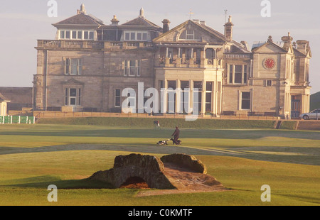 St Andrews Old Course,campo da golf in St Andrew.Foto di uomo a camminare i suoi cani con il vecchio corso club house Foto Stock