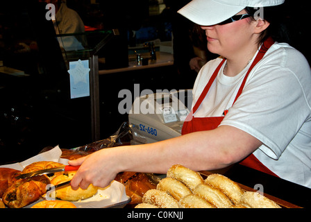 Commessa serve carne affumicata pasticceria bagel Granville Island mercato pubblico di Vancouver Foto Stock