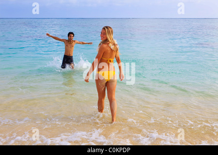 Coppia giovane frollicking presso la spiaggia di Hawaii Foto Stock