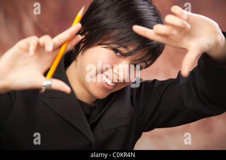 Bella ragazza multietnica pone per il suo ritratto facendo un telaio con le mani. Foto Stock