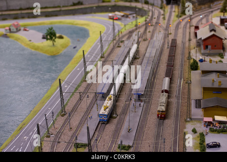 Dettaglio del modello di ferrovia giocattolo railroad pianta con la locomotiva, carro, le vie e gli edifici Foto Stock