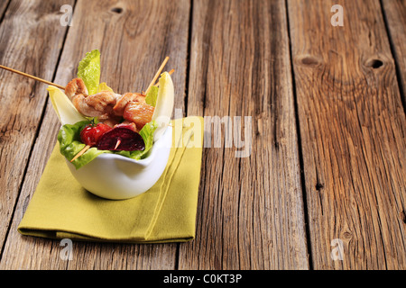Spiedini di pollo su bastoni e lattuga fresca Foto Stock